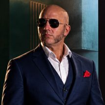 Shadow Priest, BDSM master, dominant in a blue checkered suit
